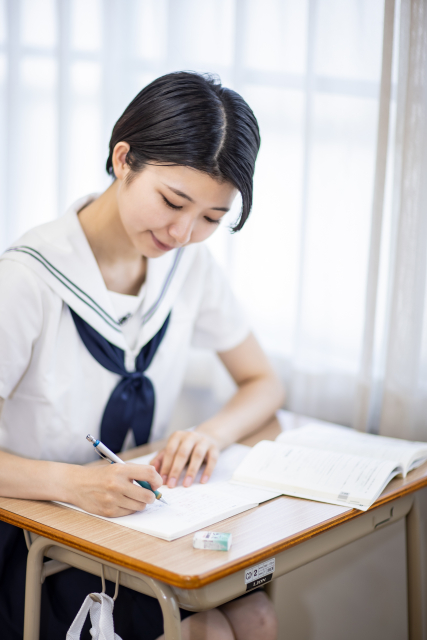ノートに記入する女生徒